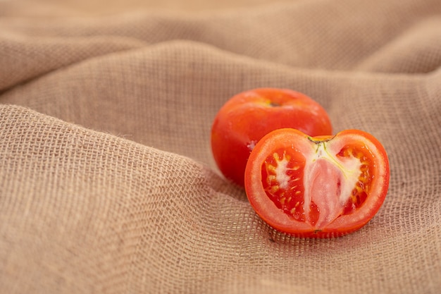 Une tomate rouge entière et une tranche isolée sur fond blanc