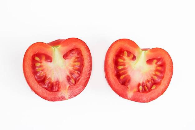 Tomate rouge fraîche coupée en deux moitiés, avec des gouttes d'eau. Légumes frais.