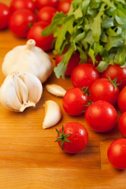 Tomates, ail et roquette sur table en bois, focus sur le premier plan