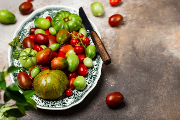 Photo tomates biologiques colorées dans une assiette vintage