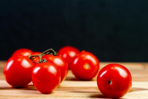 Tomates sur un bureau en bois avec fond noir