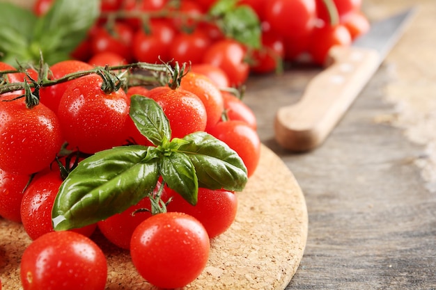 Tomates cerises au basilic sur table en bois se bouchent