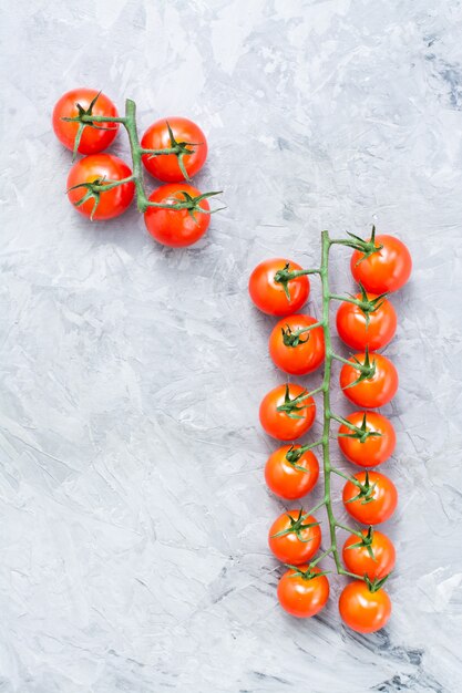 Tomates cerises au miel mûres sur une branche sur du béton