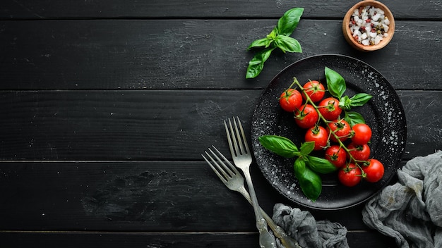 Tomates cerises et basilic dans l'assiette Vue de dessus Espace libre pour votre texte