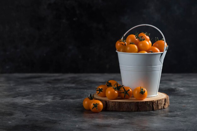 Tomates cerises sur bois avec seau en fer à décorer