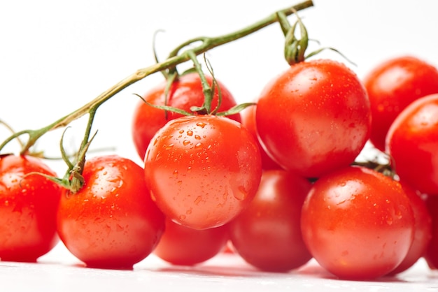 Tomates cerises sur une branche gros plan sur fond blanc