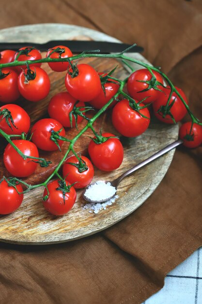 Tomates cerises sur une branche sur un plateau en bois