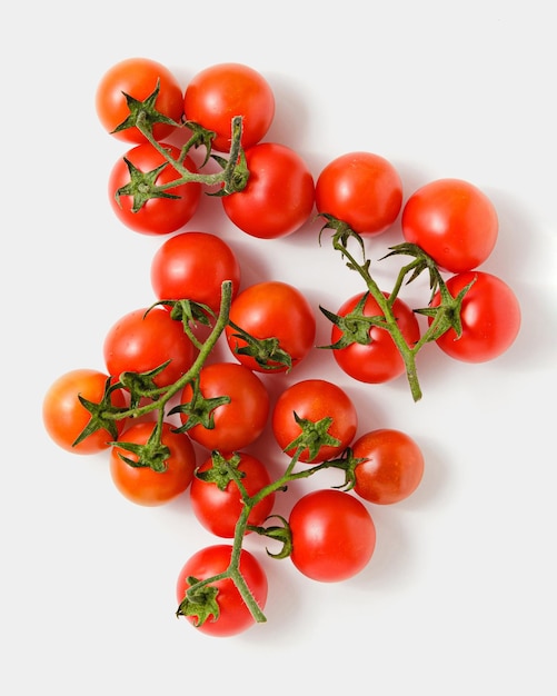 Tomates cerises sur les branches sur fond blanc