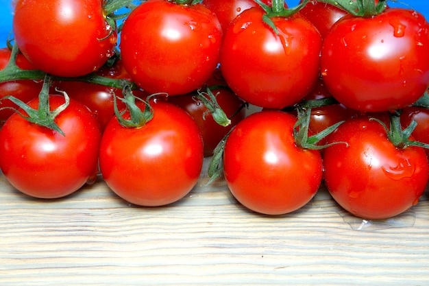 Tomates cerises sur les branches qui se trouvent sur la planche de cuisine saupoudrer ou verser de l'eau.