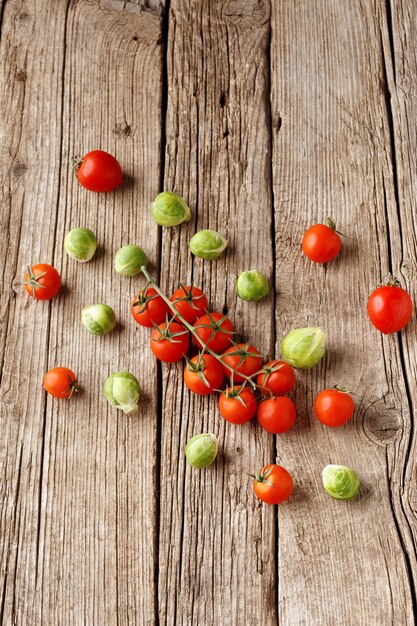 Tomates cerises et choux de Bruxelles sur un fond en bois