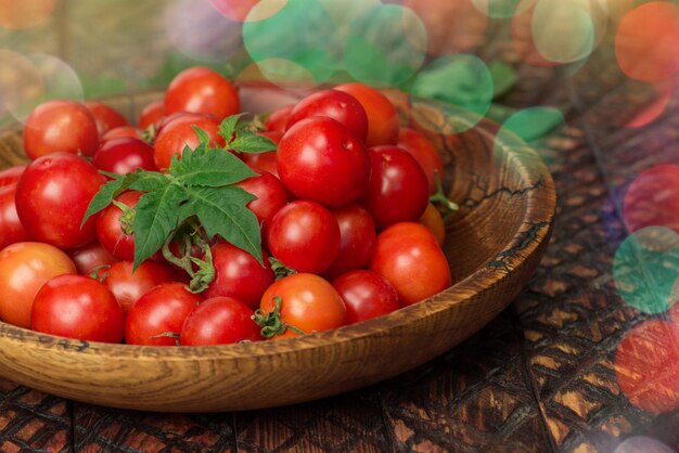 Tomates cerises dans le bol sur fond de bois foncé