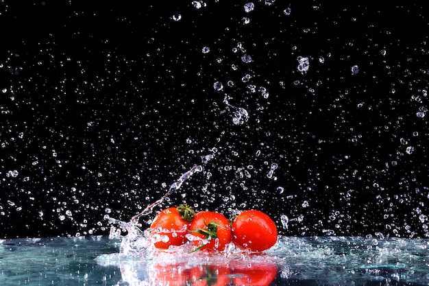 Tomates cerises dans les éclaboussures d'eau