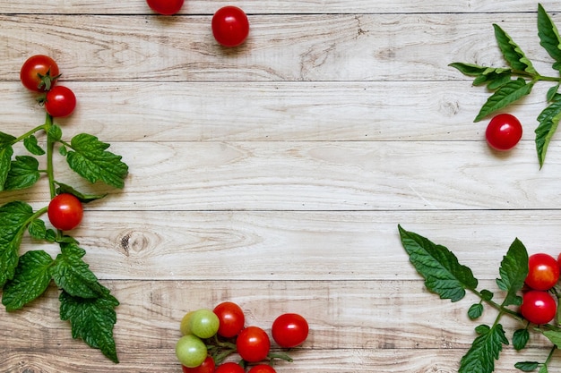 Tomates cerises sur fond de table en bois sombre lumière laisse