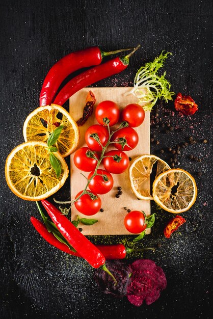 Tomates cerises fraîches aux épices sur fond noir