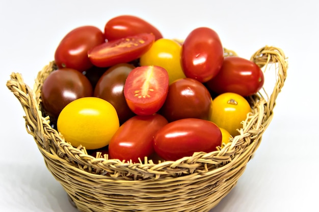 Tomates cerises fraîches et colorées sur fond blanc.