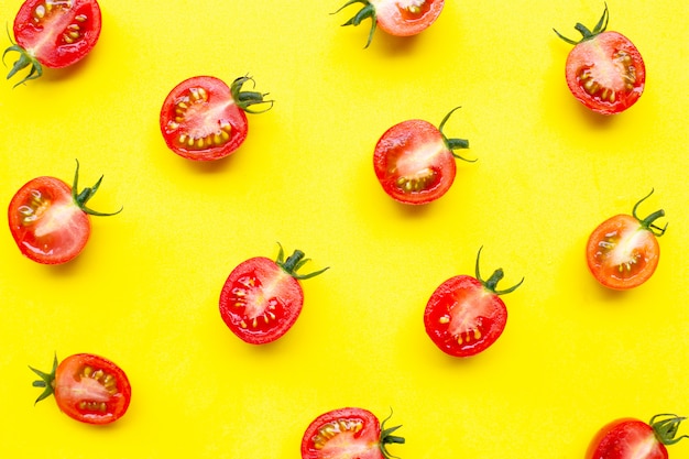 Tomates cerises fraîches, coupées à moitié isolé sur fond jaune.