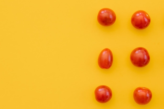 Tomates cerises fraîches sur fond jaune