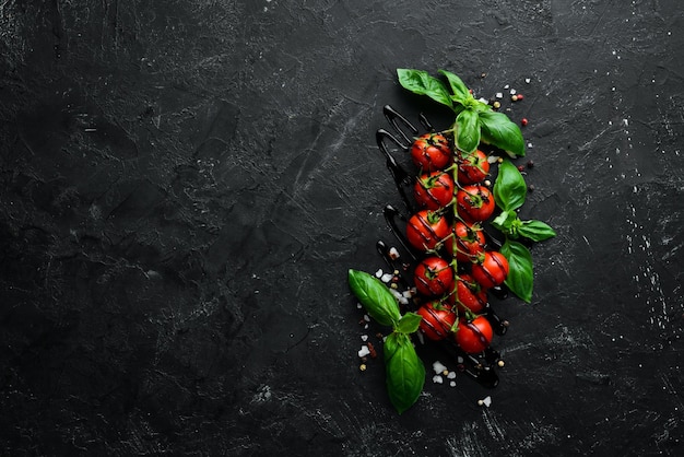 Tomates cerises fraîches sur fond noir Vue de dessus Espace libre pour votre texte