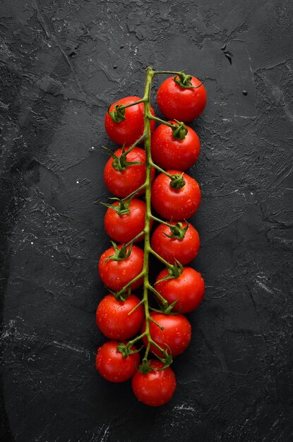 Tomates cerises fraîches sur fond noir Vue de dessus Espace libre pour votre texte