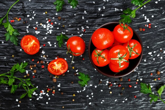 Tomates cerises fraîches en tranches avec épices gros sel et fines herbes