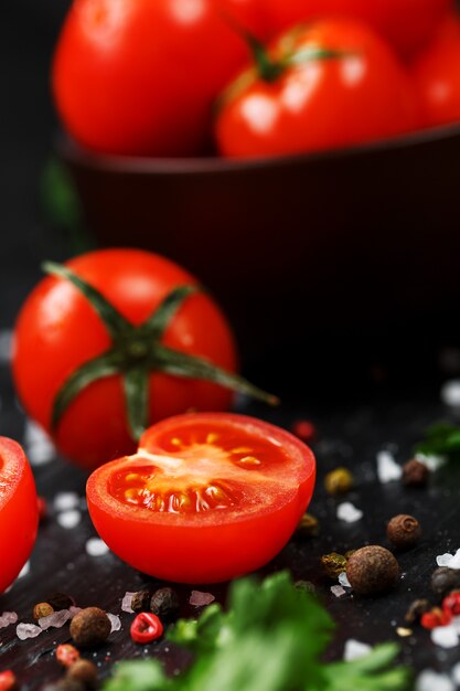 Tomates cerises fraîches en tranches avec épices gros sel et fines herbes