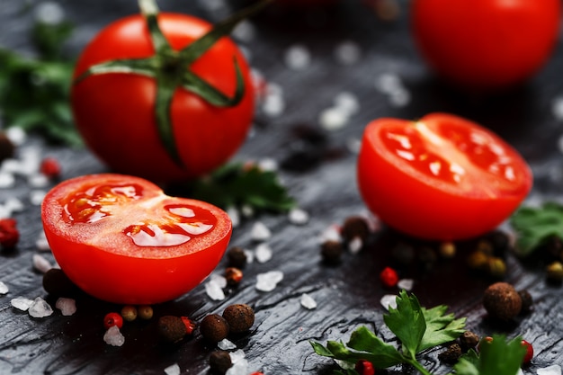 Tomates cerises fraîches en tranches avec épices gros sel et fines herbes