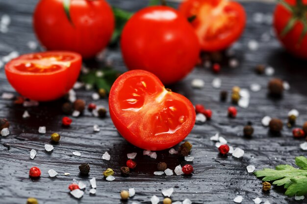 Tomates cerises fraîches en tranches avec épices gros sel et fines herbes