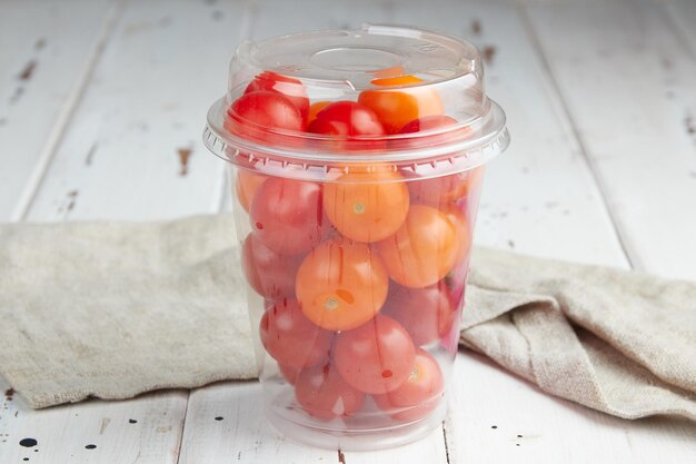 Tomates cerises jaunes fraîches sur fond de bois blanc