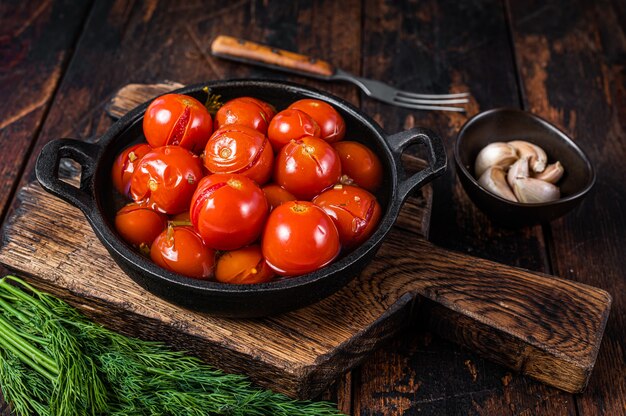 Tomates cerises marinées salées dans une casserole avec des herbes et de l'aneth