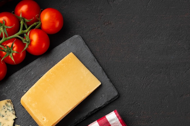 Tomates cerises et morceau de fromage sur table noire