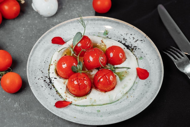 Tomates cerises avec mousse de tofu sur une assiette. lieu d'inscription.