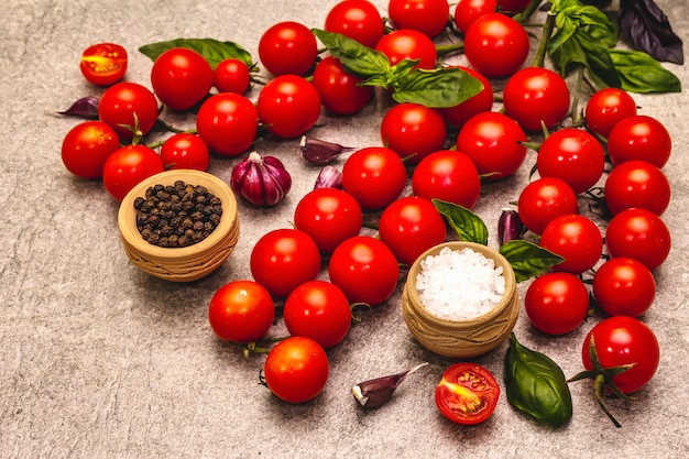 Tomates cerises mûres et épices sur fond de pierre