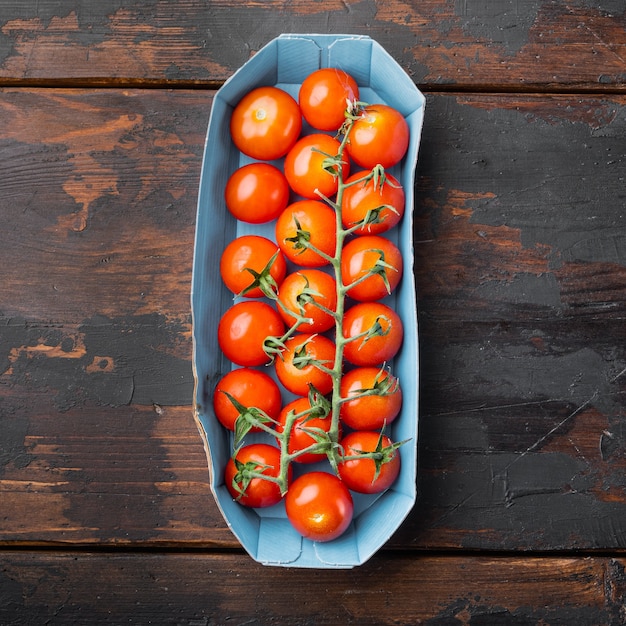 tomates cerises mûres rouges, sur une table en bois foncé