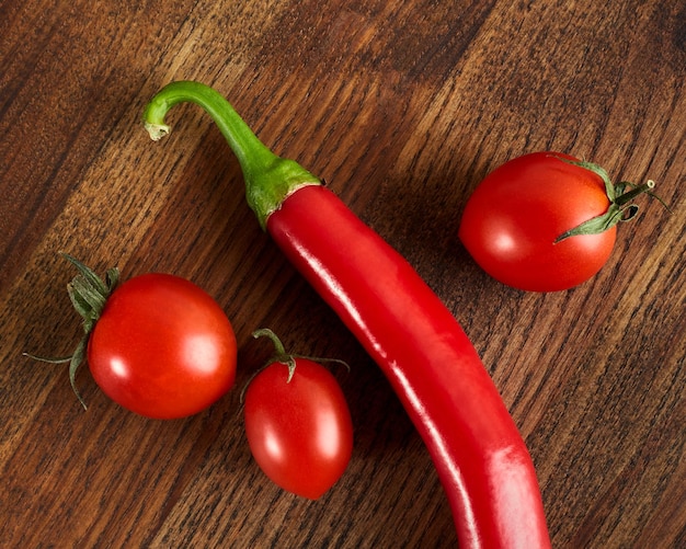 Tomates cerises et piment sur une planche en bois