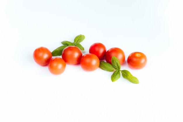 Photo tomates cerises rouges au basilic vert.