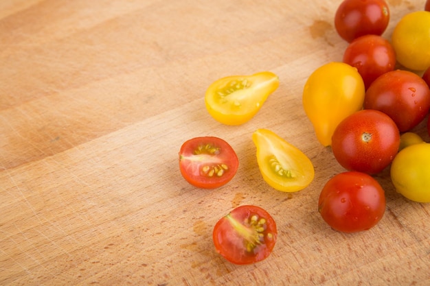 Tomates cerises rouges et jaunes sur une planche à découper en bois