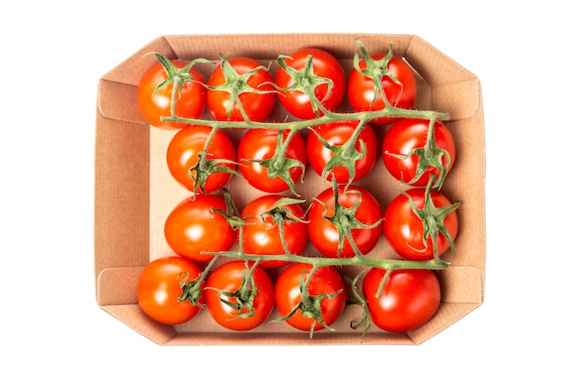 Tomates cerises rouges juteuses fraîches dans une boîte isolée. Vue de dessus.