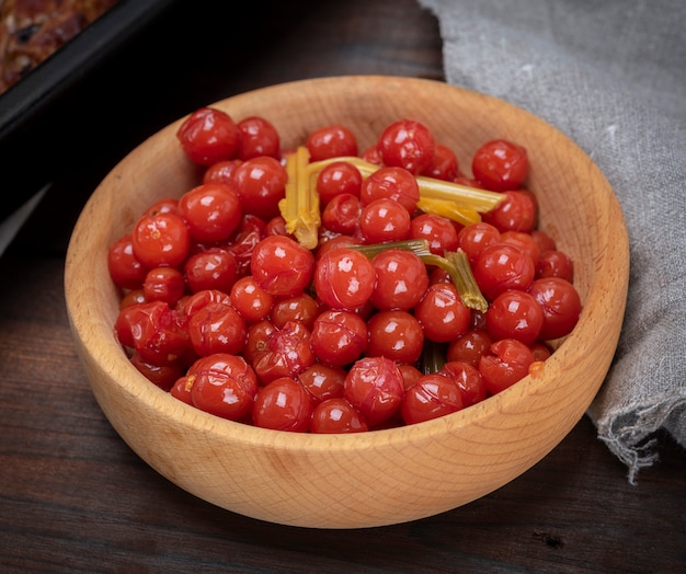 Tomates cerises rouges marinées dans un bol en bois