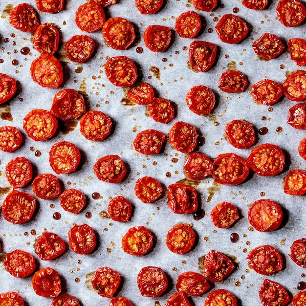 Tomates cerises séchées au soleil avec huile d'olive et vinaigre balsamique sur papier sulfurisé. Vue de dessus, fond de nourriture. Image carrée