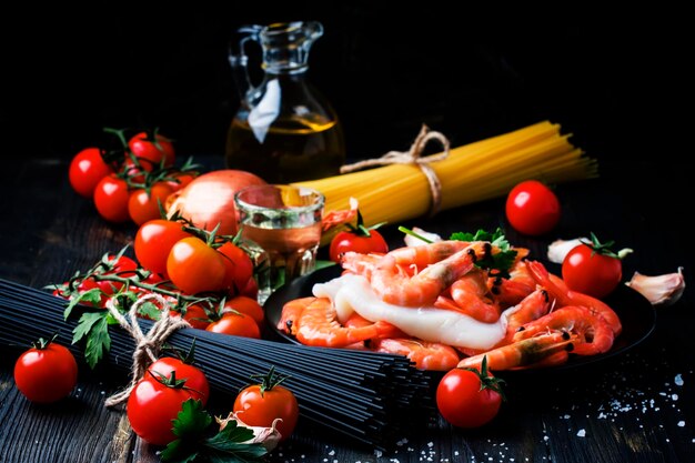 Tomates cerises spaghettis noirs calamars de crevettes au vin blanc nature morte dans une mise au point sélective discrète