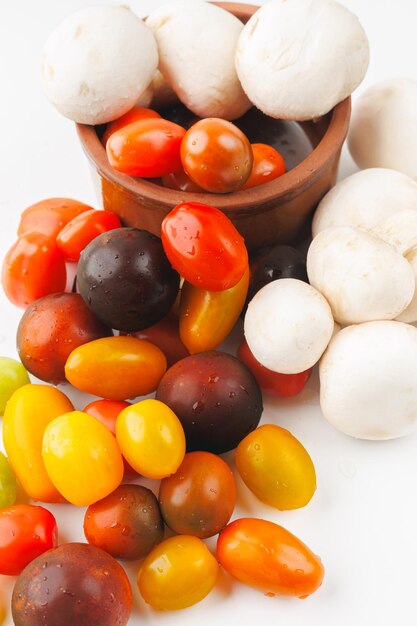 Photo des tomates et des champignons colorés sur fond blanc en gros plan