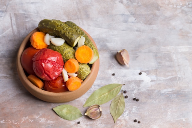 Tomates choucroute et concombres aux carottes, ail, feuille de laurier dans une vaisselle