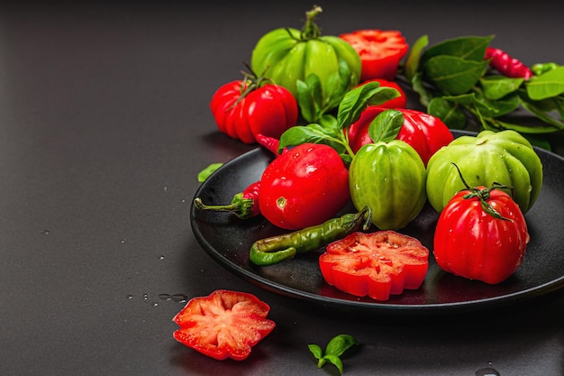 Tomates côtelées vertes et rouges Variété américaine ou florentine Légumes mûrs Feuilles de laurier fraîches