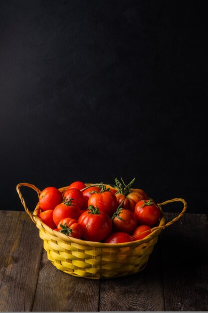 Photo tomates cultivées dans un potager dans un panier en osier sur une table en bois