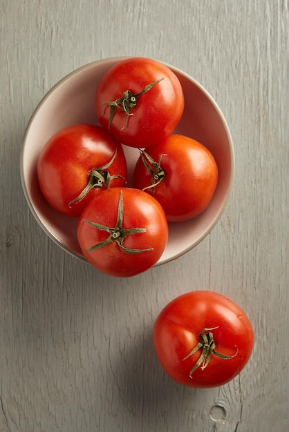 Photo tomates dans un bol sur un fond en bois