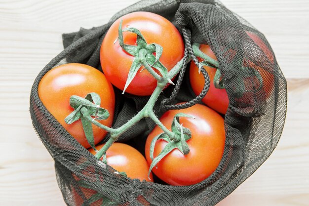 Tomates dans un sac à provisions réutilisable sur une table en bois Le concept de mode de vie zéro déchet et respectueux de l'environnement Pas de plastique Vue de dessus