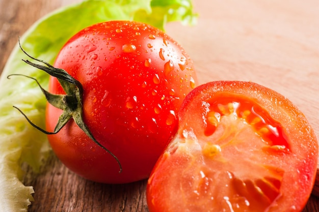 Tomates entières et demi sur un fond en bois