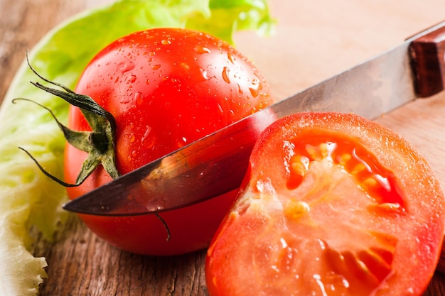 Tomates entières et demi sur un fond en bois