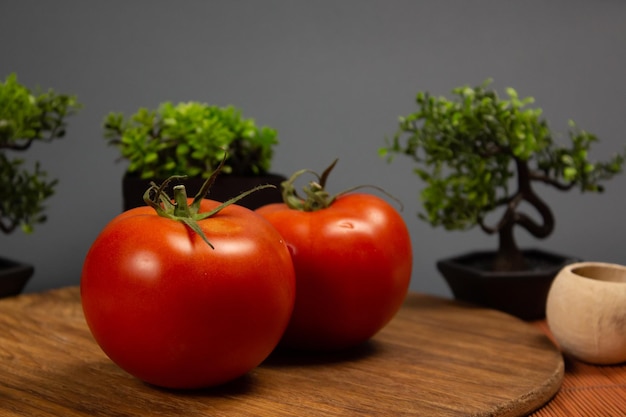 Tomates sur fond sombre. Verts et cuisson. Collection de tomates. Nature morte.