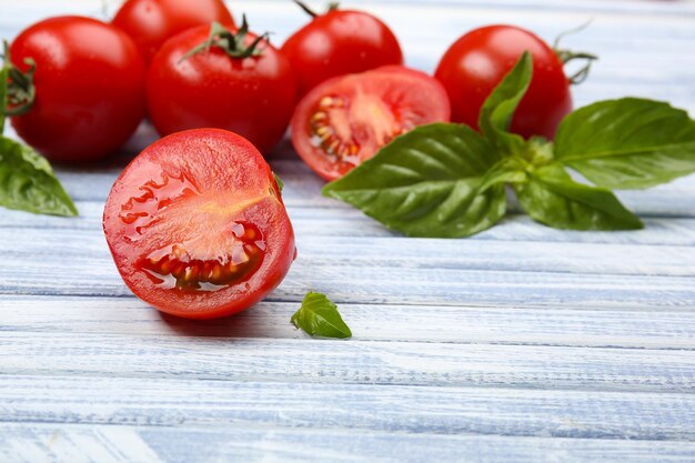 Tomates fraîches au basilic sur table en bois se bouchent